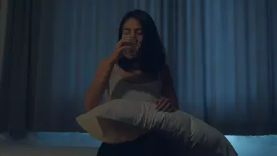 woman drinking water in bed at night