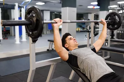 man lifting weights in gym